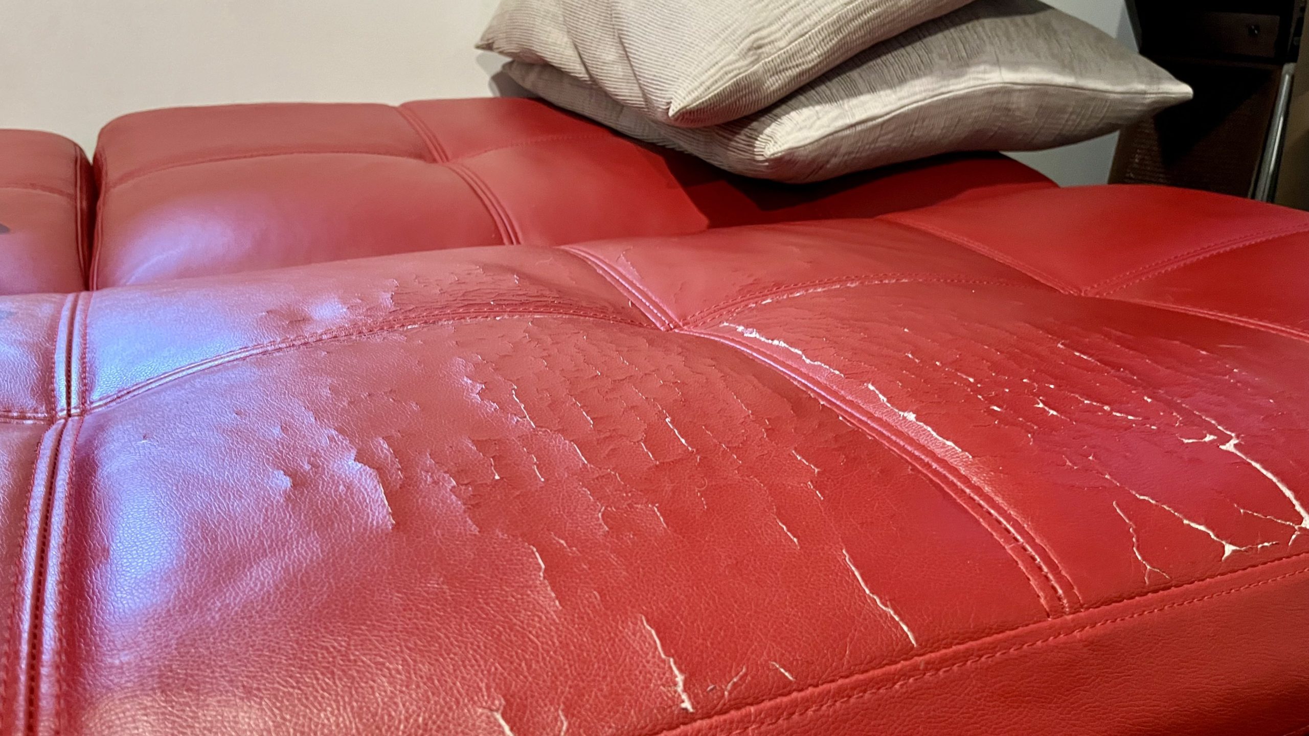 Photo of the Coddle Toggle couch in mattress mode, showing cracked leather after about 3.5 years of normal use